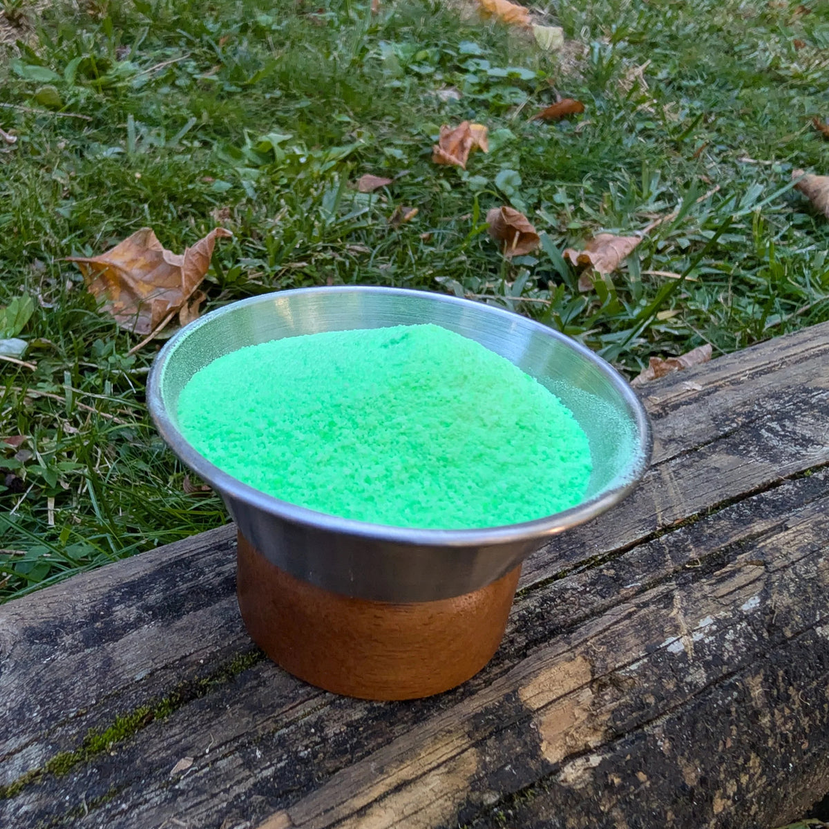 Bowl of Toad's Poison bright green fizzy powder on a log