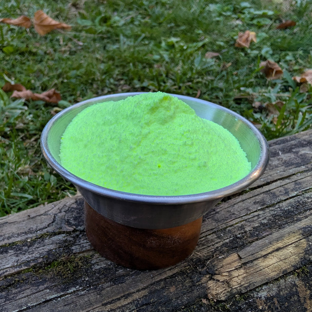 Bowl of Liquid Gold yellow-green fizzy powder on a log