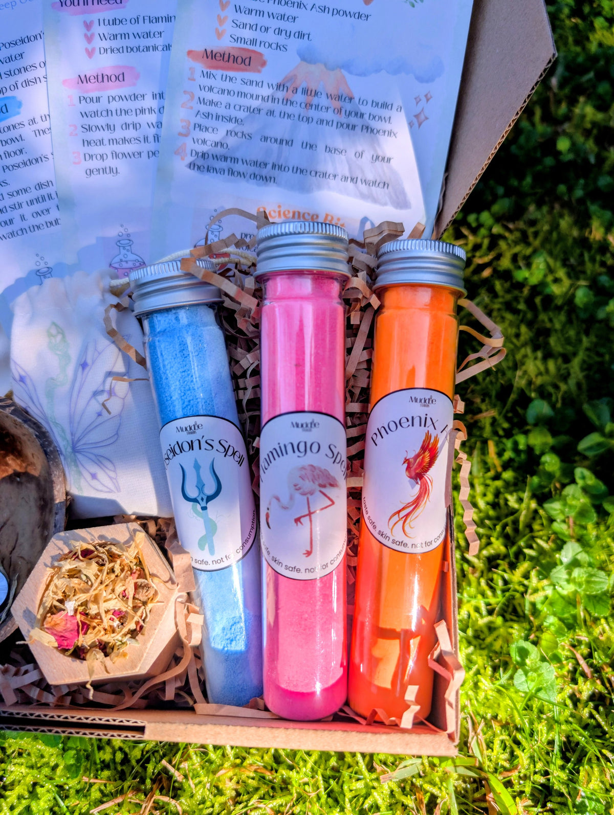 Close up of Muddle & Play recipe cards and blue, pink and orange test tubes in the box