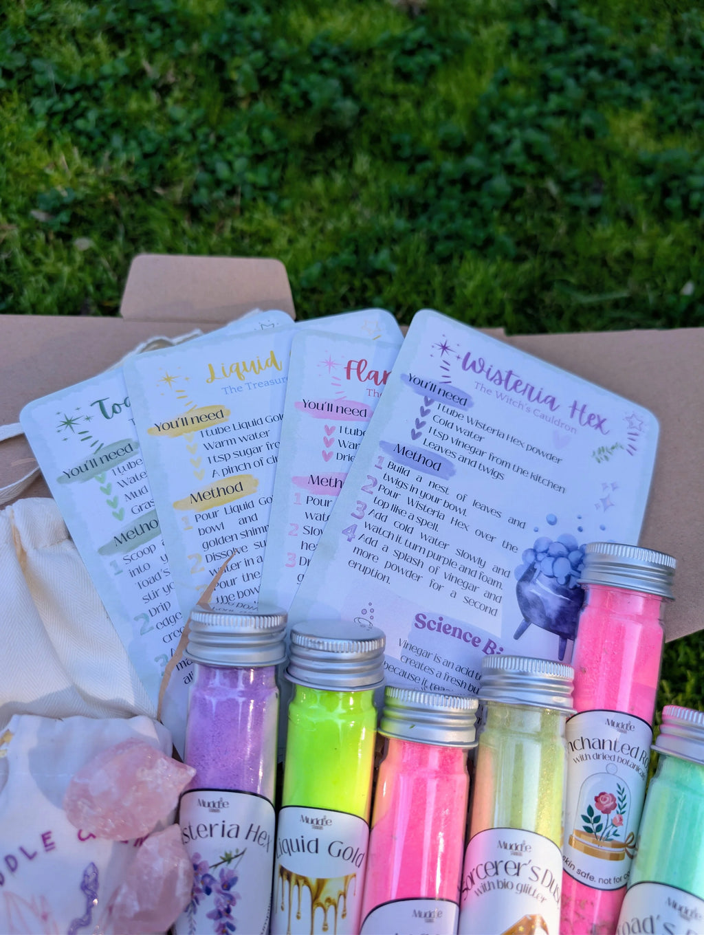 Close up of Muddle & Enchant story cards and row of colourful test tubes 