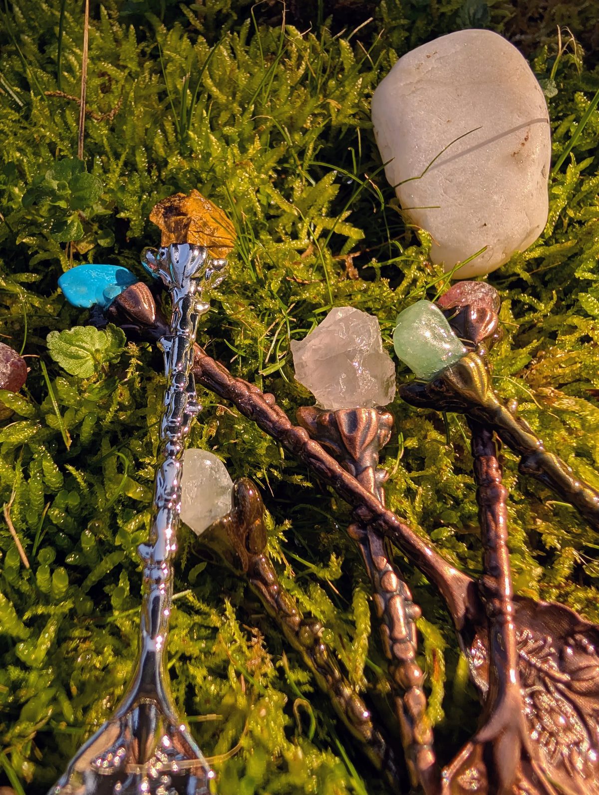 Close up of gemstone spoon handles in turquoise and orange on grass 