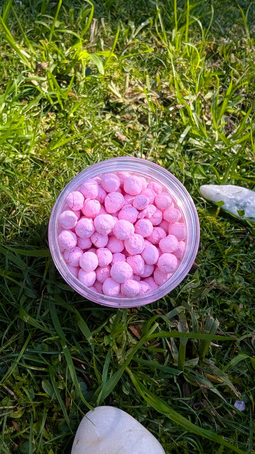 Open jar of Blush Dawn Pearls, pink tapioca pearls, seen from above on grass 