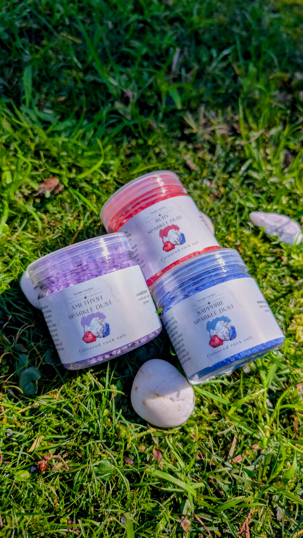 Amethyst, Ruby and Sapphire Sparkle Dust jars grouped together on grass 
