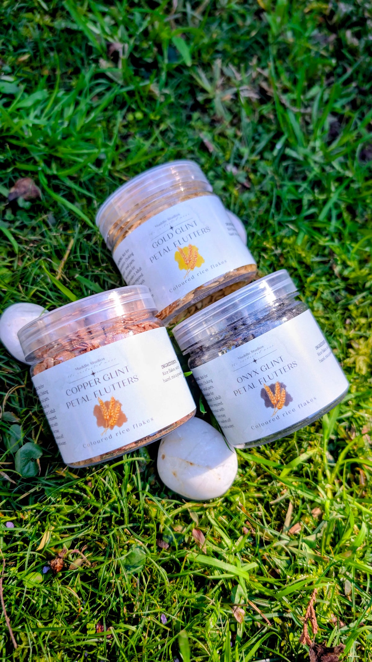 Copper, Gold and Onyx Glint Petal Flutters jars grouped together on grass