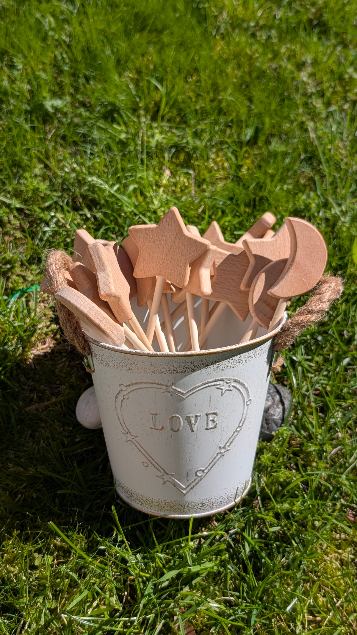 Wooden potion wands with star and heart toppers standing in a white metal bucket